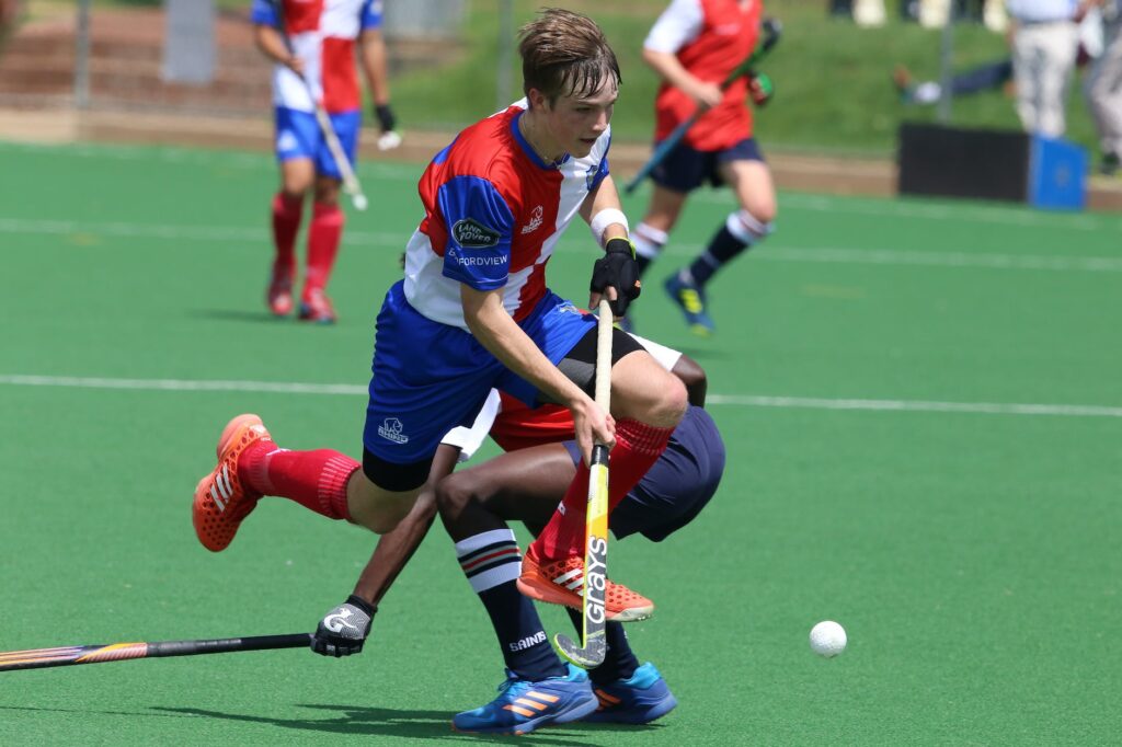 man in red and blue jersey shirt playing hockey